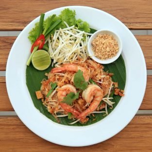 Padthai, Noodle Stir-fried with shrimp on white plate at wood table.