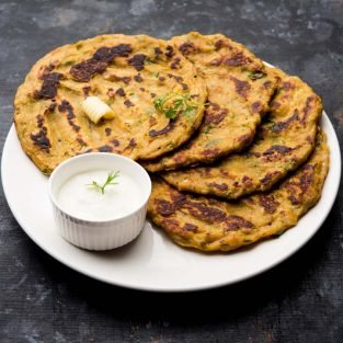 Thalipeeth is a type of savoury multi-grain pancake popular in Maharashtra, India served with curd/butter or ghee